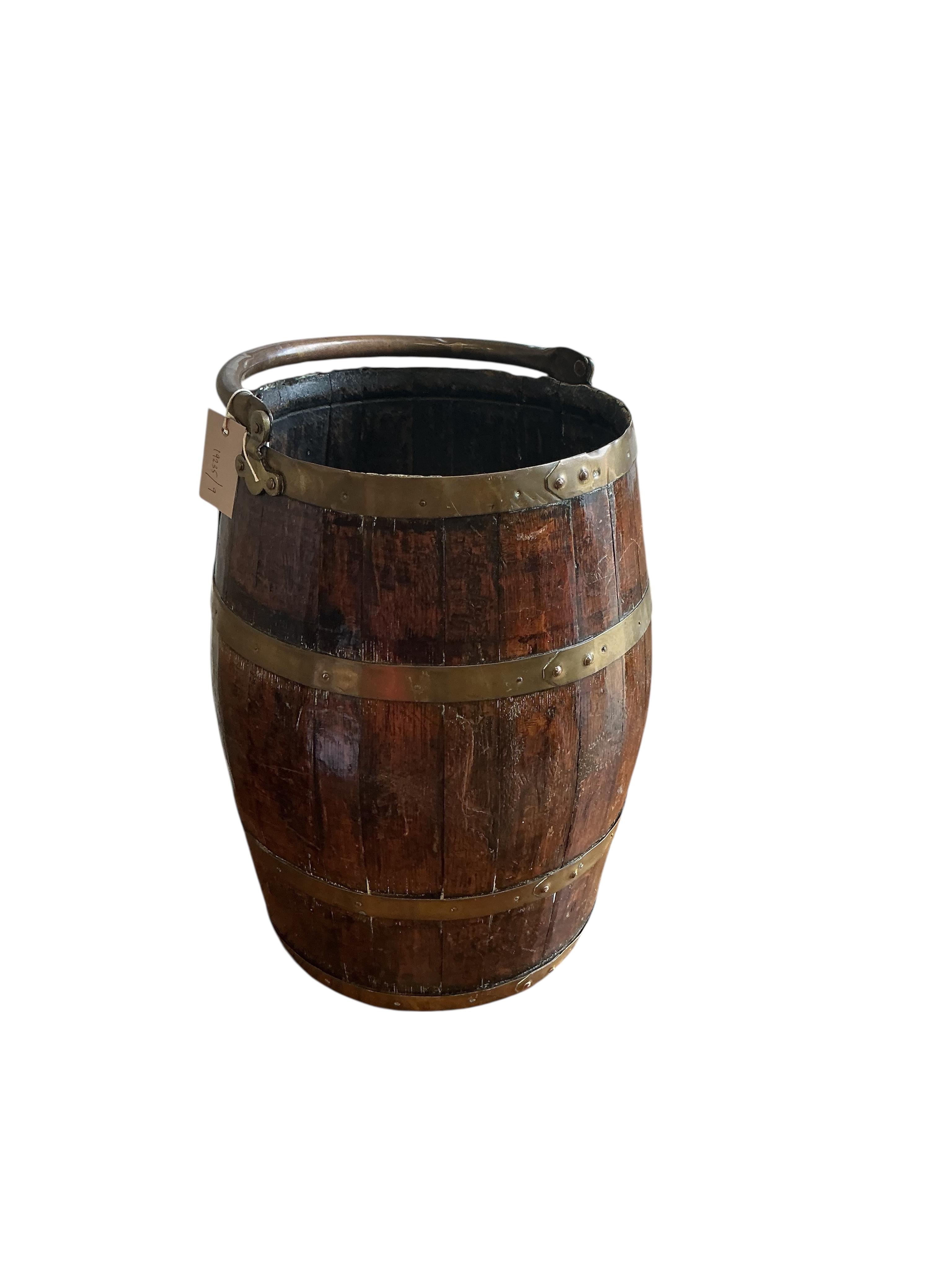 A brass bound coopered oak barrel with swing handle, height 48cm